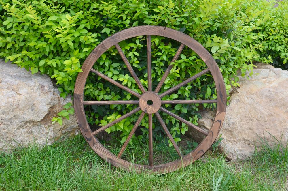 "Rustic wooden wagon wheel 48 inch for garden decor"

"Burnt wood wagon wheel leaning against a fence"

"Farmhouse yard display with decorative wooden wheels"
