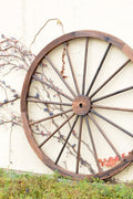 "Rustic wooden wagon wheel 48 inch for garden decor"

"Burnt wood wagon wheel leaning against a fence"

"Farmhouse yard display with decorative wooden wheels"