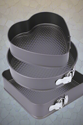 3-piece black non-stick springform pan set stacked

Close-up of leakproof buckle system and honeycomb base

Pan sizes and removable bottoms shown in open position

Full set displayed with baked cake example

Pans nested and stored compactly on kitchen counter