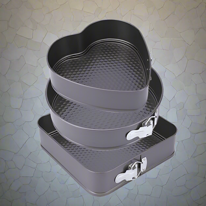 3-piece black non-stick springform pan set stacked

Close-up of leakproof buckle system and honeycomb base

Pan sizes and removable bottoms shown in open position

Full set displayed with baked cake example

Pans nested and stored compactly on kitchen counter