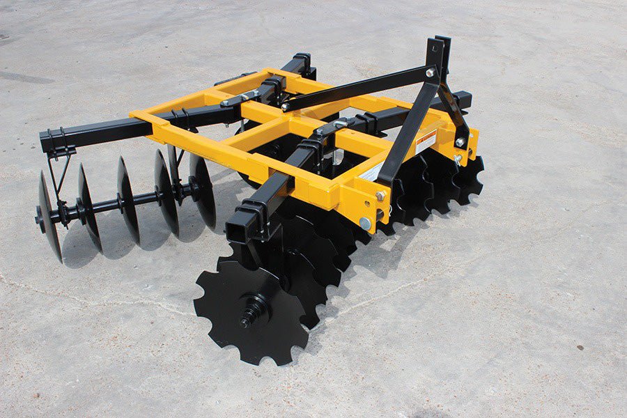 8 ft yellow 3-point tractor disc harrow with notched blades/
Close-up of notched disc blades, double taper bearing system