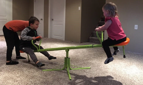 Kids spinning on green 360° seesaw in backyard
360-degree rotating seesaw with blue seats and soft handles
Outdoor seesaw with rotation and bounce action
Side view of children playing on rotating seesaw
Playground toy for toddlers and young kids