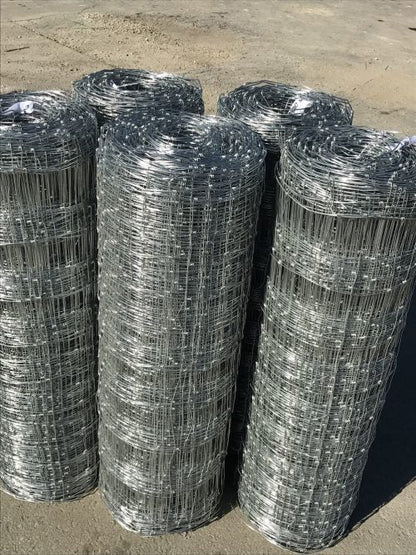Rolled 330 FT livestock wire fence – silver steel

Close-up of barbed top and bottom wire fencing

Field wire fence rolls stacked on pallet – 4FT and 5FT

Product chart showing wire spacing and gauge specs