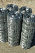 Rolled 330 FT livestock wire fence – silver steel

Close-up of barbed top and bottom wire fencing

Field wire fence rolls stacked on pallet – 4FT and 5FT

Product chart showing wire spacing and gauge specs