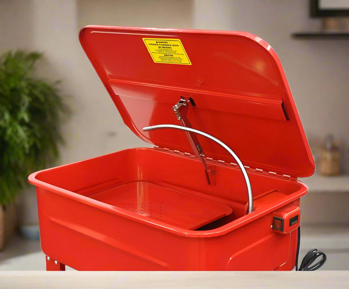 Top view of parts washer basin with solvent hose, lid hinge, and filtration tray