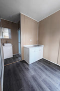 Exterior view of 40 FT insulated container office cabin

Interior layout showing vinyl flooring and workstations

TPS insulated walls and faux leather trim details

Plumbing and water system built into mobile cabin

Rear angle showing door and window design