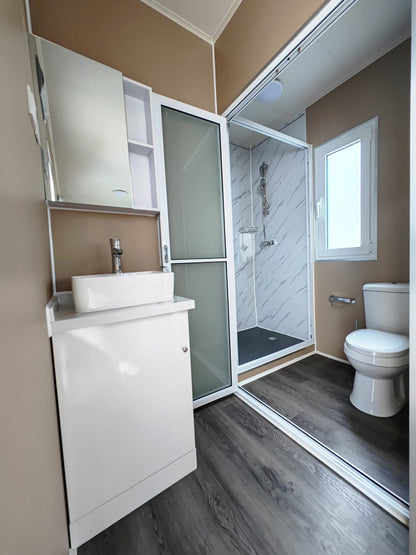 Exterior view of 40 FT insulated container office cabin

Interior layout showing vinyl flooring and workstations

TPS insulated walls and faux leather trim details

Plumbing and water system built into mobile cabin

Rear angle showing door and window design