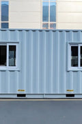 Exterior view of 40 FT insulated container office cabin

Interior layout showing vinyl flooring and workstations

TPS insulated walls and faux leather trim details

Plumbing and water system built into mobile cabin

Rear angle showing door and window design