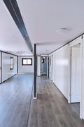 Brightly lit bedroom space with laminate flooring in prefab unit