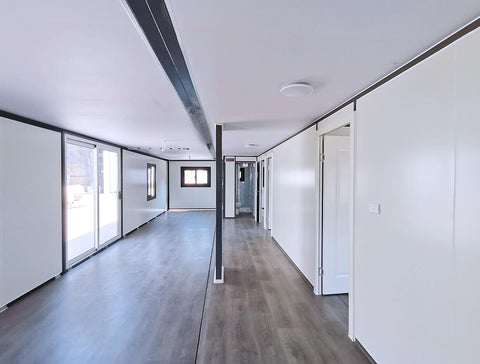 Brightly lit bedroom space with laminate flooring in prefab unit