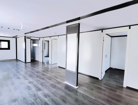 Wide interior view showing living area and entryway of prefab house