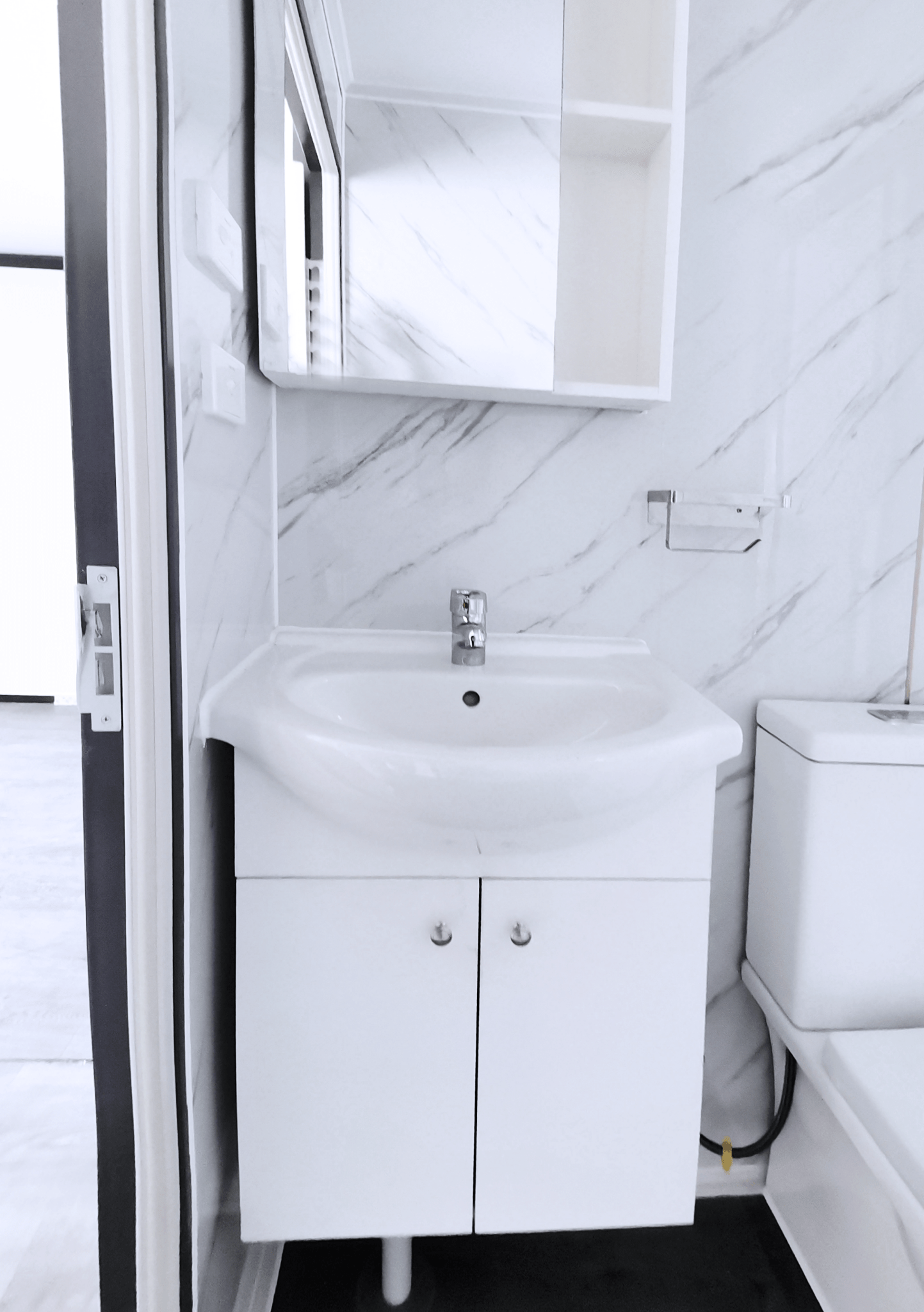 Bathroom view with mounted vanity and under-sink cabinet