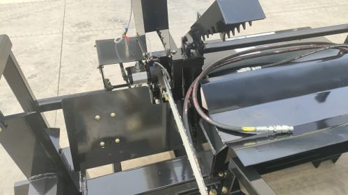 Skid steer firewood processor with 45-ton splitter attached
Log splitter with Stihl saw mounting plate
Firewood processing log cradle and splitting wedge
Heavy-duty 45-ton log processor on worksite
Operator splitting wood from skid steer seat