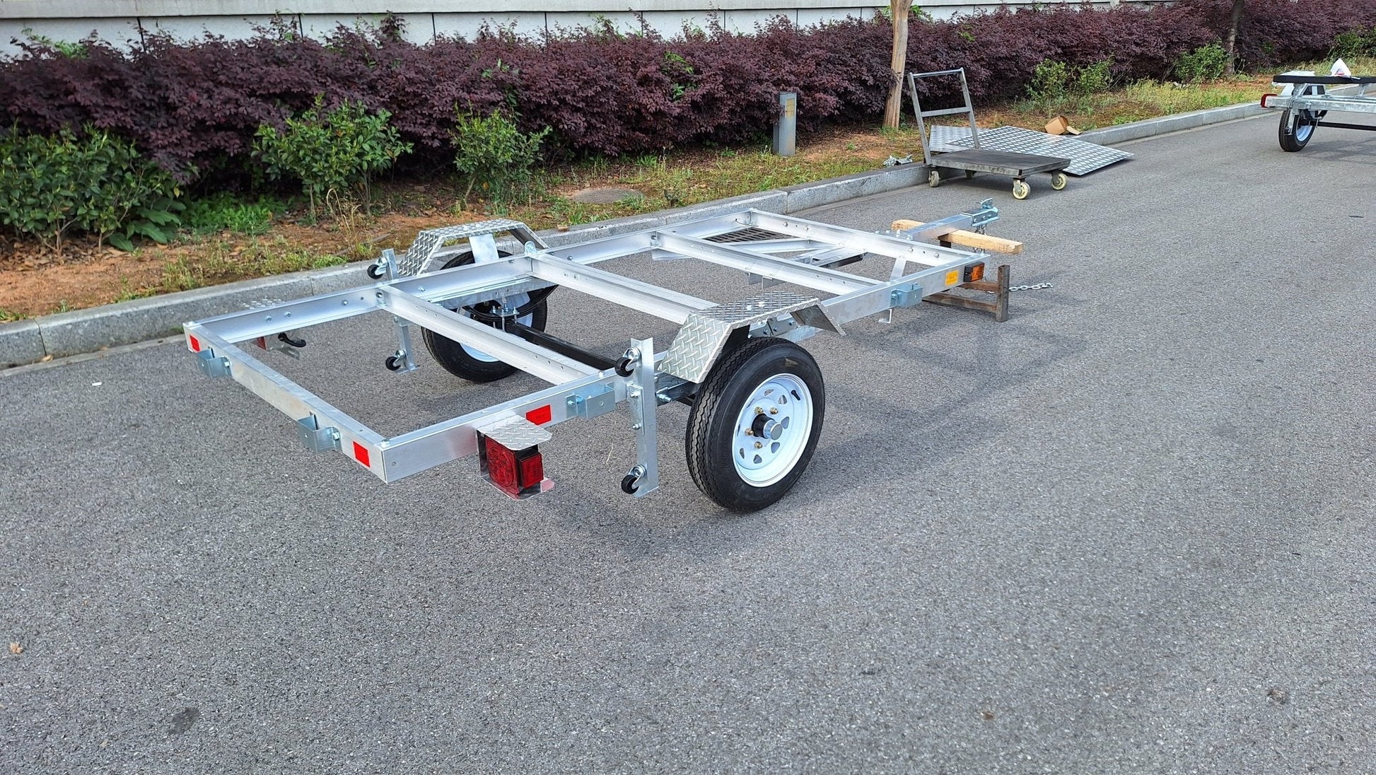 "4x8 folding aluminum utility trailer with built-in casters"

"Space-saving lightweight trailer for small vehicle hauling"

"Compact aluminum trailer folded vertically for storage"
