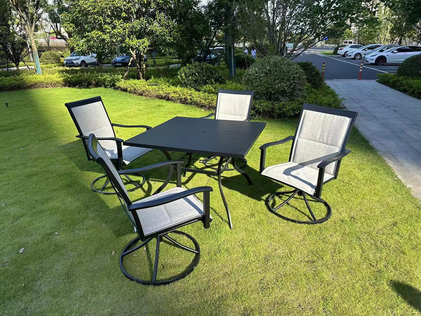 5-piece outdoor swivel dining set in garden setup

Black swivel dining chairs with cushions

Round glass-top patio dining table

Outdoor dining set with umbrella

Side view of black patio chairs and table