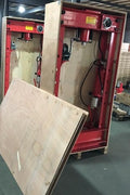 Shop technician using 50 Ton hydraulic press for metal forming