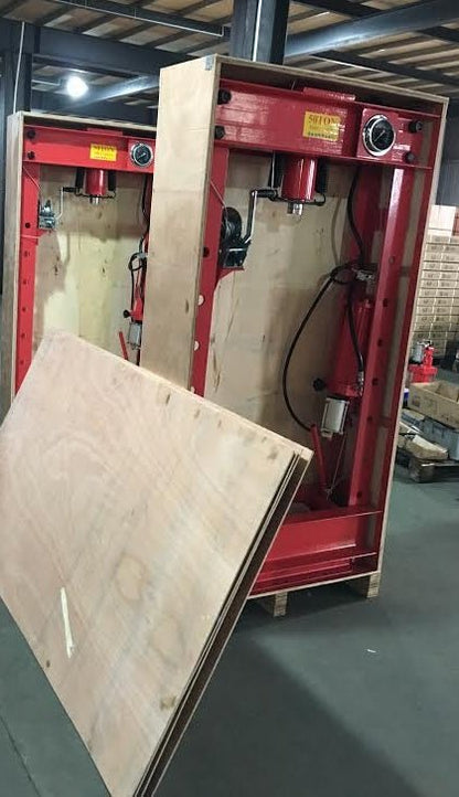 Shop technician using 50 Ton hydraulic press for metal forming