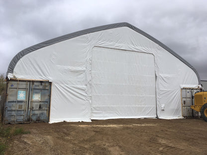 50x80 ft all-white PVC double truss fabric shelter installed over shipping containers – heavy-duty industrial storage building