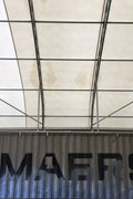50x80 ft all-white PVC double truss fabric shelter installed over shipping containers – heavy-duty industrial storage building