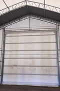 50x80 ft all-white PVC double truss fabric shelter installed over shipping containers – heavy-duty industrial storage building