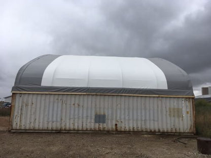 50x80 ft all-white PVC double truss fabric shelter installed over shipping containers – heavy-duty industrial storage building