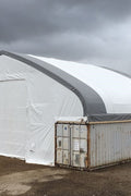 50x80 ft all-white PVC double truss fabric shelter installed over shipping containers – heavy-duty industrial storage building