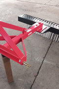 Red 5 FT landscape rake for tractor with 3-point hitch

Side view of landscape rake attachment on concrete

Close-up of tine design and mounting frame

3-point hitch mount landscape rake back view