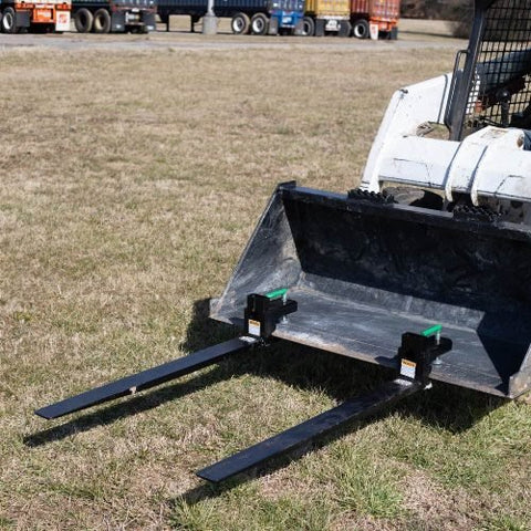 Heavy-duty clamp-on pallet forks attached to tractor bucket
Side view of 60-inch pallet forks with stabilizer bar
Close-up of fork clamps and locking bolts
Rear view showing rollback guard on pallet fork
Forks lifting lumber/crates on farm terrain