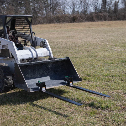 Heavy-duty clamp-on pallet forks attached to tractor bucket
Side view of 60-inch pallet forks with stabilizer bar
Close-up of fork clamps and locking bolts
Rear view showing rollback guard on pallet fork
Forks lifting lumber/crates on farm terrain