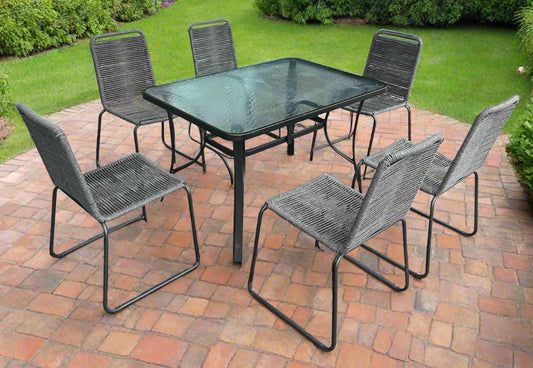 Full 7-piece patio dining set with 6 chairs and steel table

Close-up of stackable outdoor chair with armrest

Outdoor dining table surface with modern weather-resistant finish

Chairs stacked for space-saving storage

Patio dining set placed in backyard setting