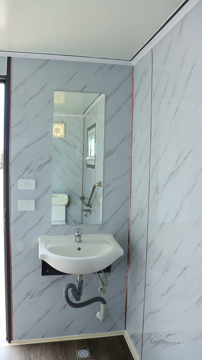 7-foot ADA-compliant portable restroom with ramp in outdoor setting
Inside view of wheelchair-accessible bathroom interior
Front door of handicap bathroom unit with ramp
Washbasin and toilet setup in ADA portable unit
Side view of accessible bathroom setup