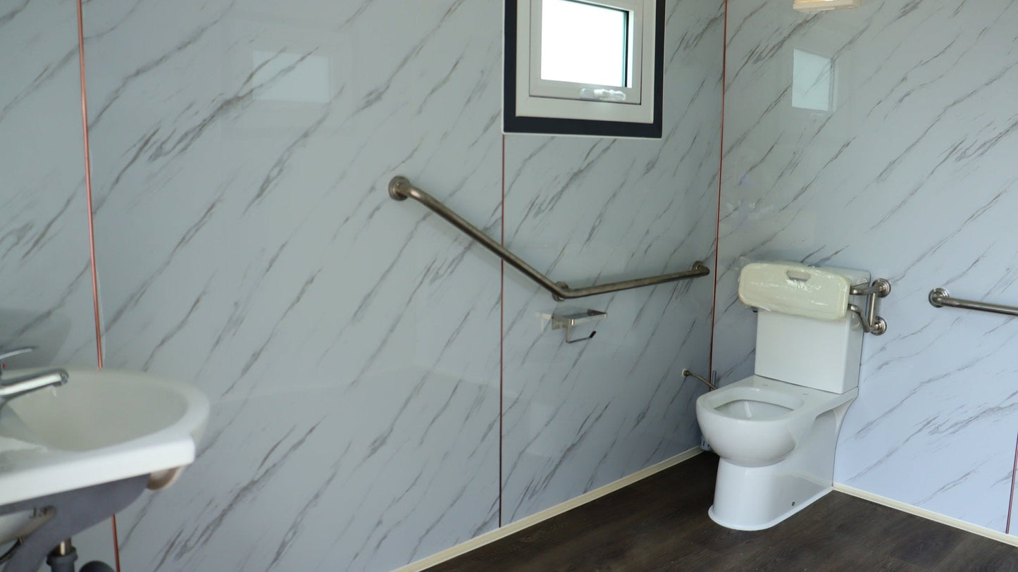 7-foot ADA-compliant portable restroom with ramp in outdoor setting
Inside view of wheelchair-accessible bathroom interior
Front door of handicap bathroom unit with ramp
Washbasin and toilet setup in ADA portable unit
Side view of accessible bathroom setup