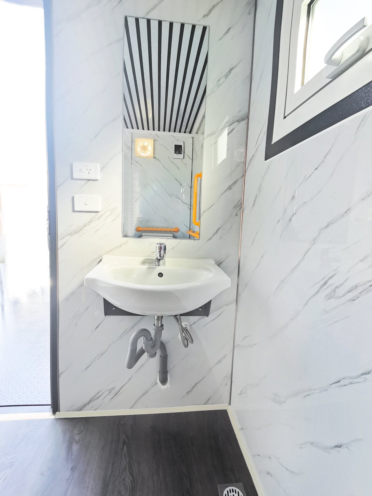 7-foot ADA-compliant portable restroom with ramp in outdoor setting
Inside view of wheelchair-accessible bathroom interior
Front door of handicap bathroom unit with ramp
Washbasin and toilet setup in ADA portable unit
Side view of accessible bathroom setup