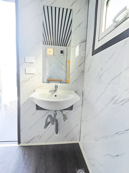 7-foot ADA-compliant portable restroom with ramp in outdoor setting
Inside view of wheelchair-accessible bathroom interior
Front door of handicap bathroom unit with ramp
Washbasin and toilet setup in ADA portable unit
Side view of accessible bathroom setup