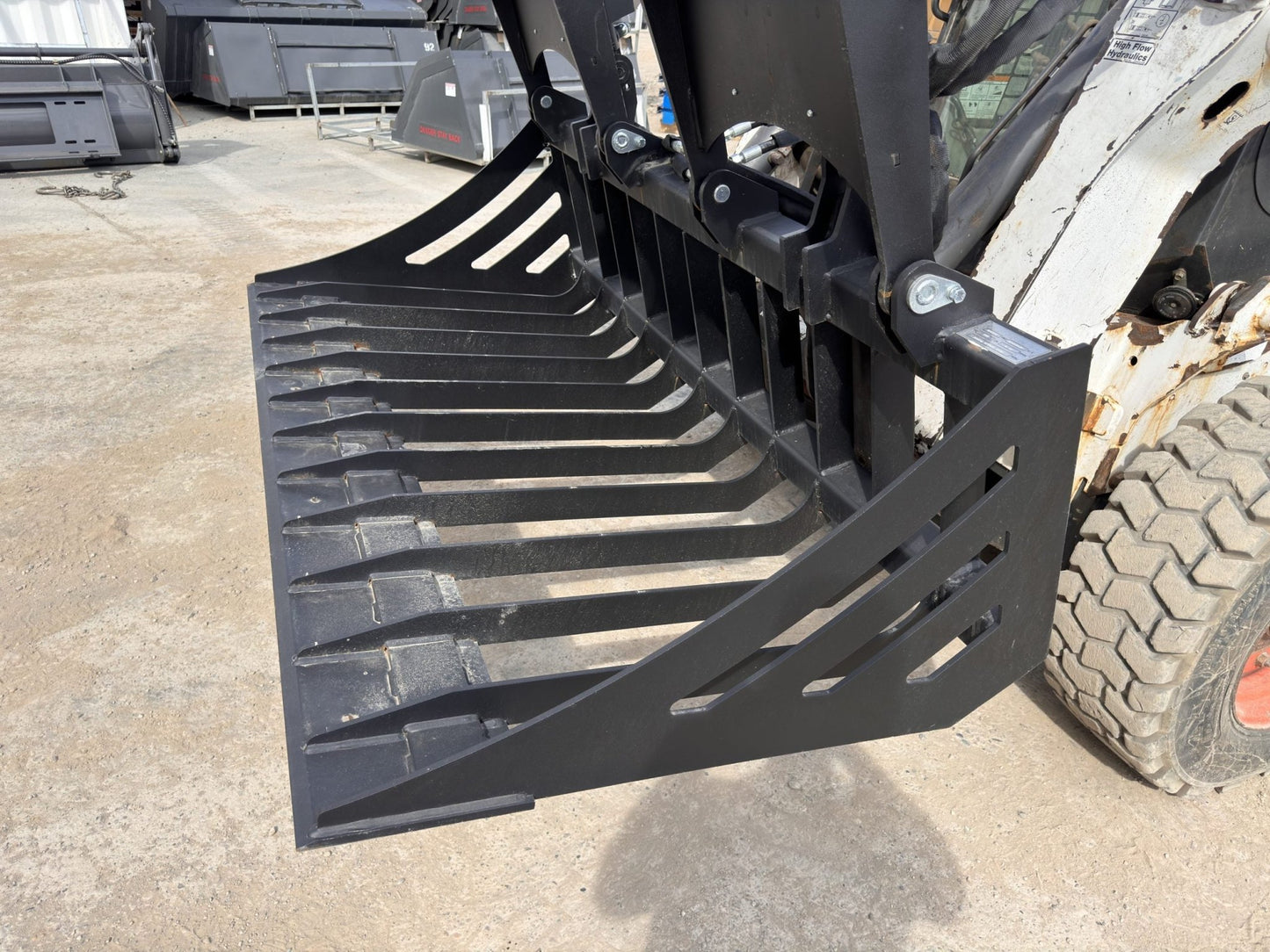 72" hydraulic grapple bucket on skid steer

Skid steer rock grapple front view

Close-up of grapple teeth and hoses

Dual-cylinder grapple open position

Grapple attachment lifting heavy debris