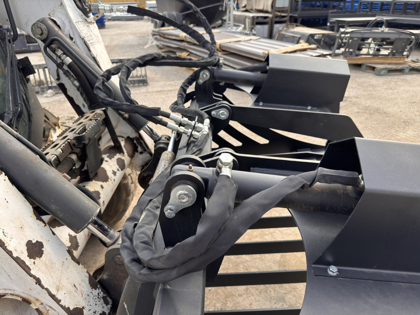 72" hydraulic grapple bucket on skid steer

Skid steer rock grapple front view

Close-up of grapple teeth and hoses

Dual-cylinder grapple open position

Grapple attachment lifting heavy debris
