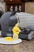 7.5 inch electric meat and deli slicer on kitchen counter
Adjustable food thickness dial and stainless steel blade
Compact electric slicer with food pusher in use
Top view of food slicer showing aluminum body
Deli meat sliced using electric food cutter
