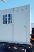 Gray 7FT steel office container with side door and windows
Interior view of 12FT jobsite office sea container
Office container unit with swing door and locking system
Plywood flooring inside portable office container
Security window with locking bar on steel sea container