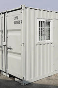 Gray 7FT steel office container with side door and windows
Interior view of 12FT jobsite office sea container
Office container unit with swing door and locking system
Plywood flooring inside portable office container
Security window with locking bar on steel sea container