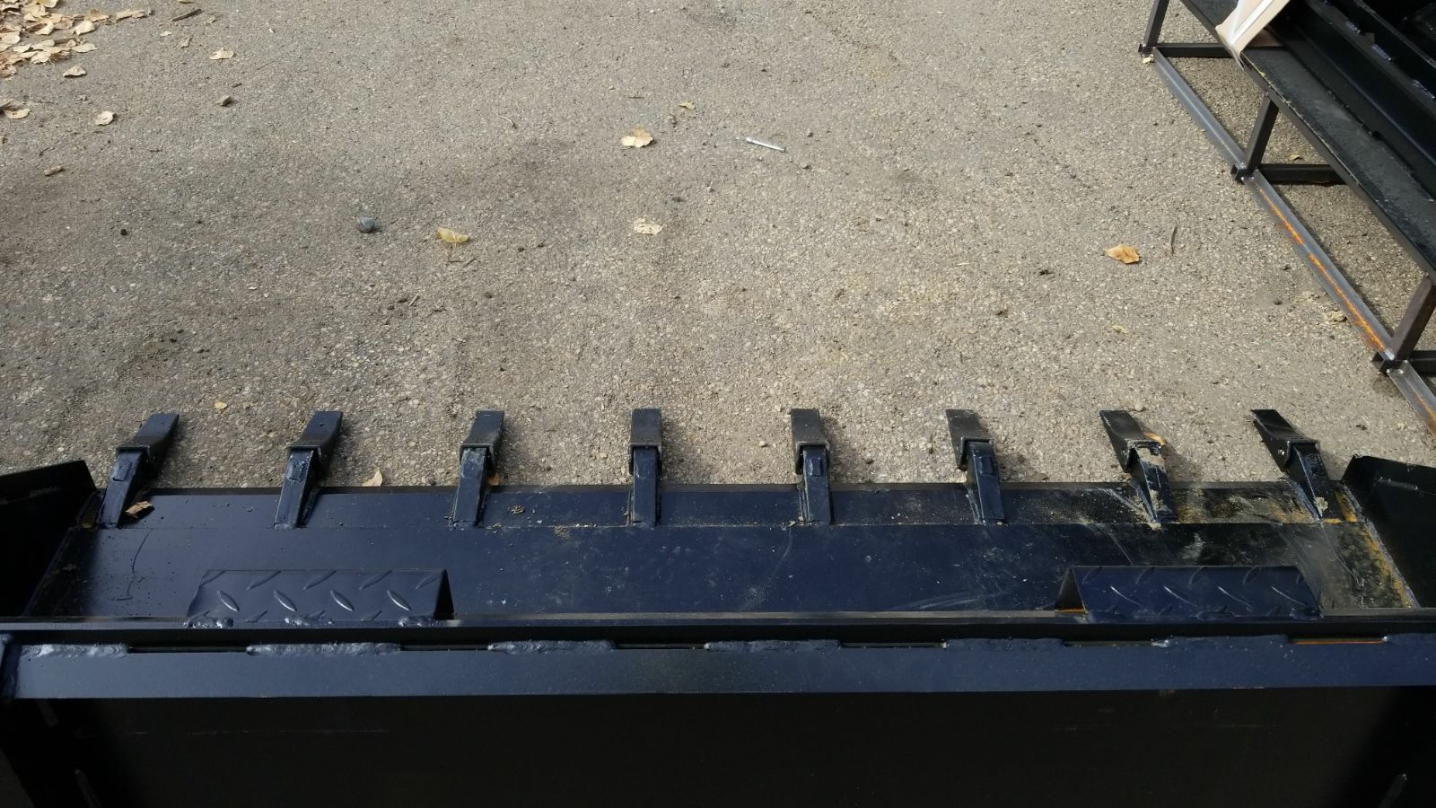 80" skid steer digging bucket with removable teeth

Heavy-duty bucket on job site with loader

Front view of 84-inch skid steer bucket

Skid steer digging into dirt with steel bucket

Wear strips and teeth close-up for material handling