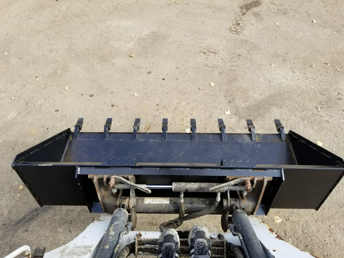 80" skid steer digging bucket with removable teeth

Heavy-duty bucket on job site with loader

Front view of 84-inch skid steer bucket

Skid steer digging into dirt with steel bucket

Wear strips and teeth close-up for material handling
