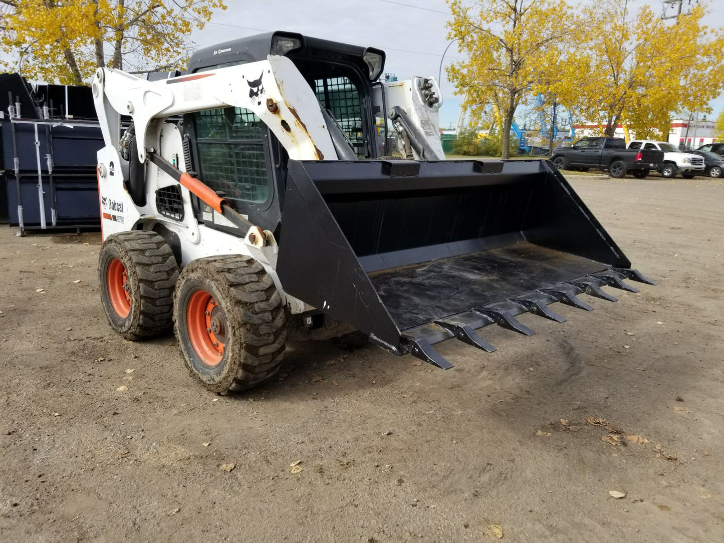 80" skid steer digging bucket with removable teeth

Heavy-duty bucket on job site with loader

Front view of 84-inch skid steer bucket

Skid steer digging into dirt with steel bucket

Wear strips and teeth close-up for material handling