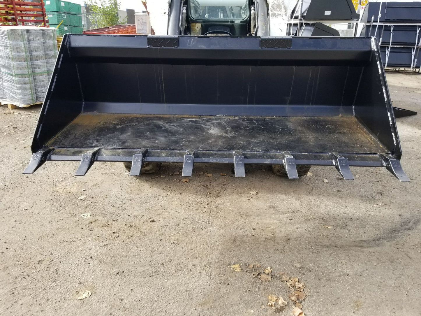 80" skid steer digging bucket with removable teeth

Heavy-duty bucket on job site with loader

Front view of 84-inch skid steer bucket

Skid steer digging into dirt with steel bucket

Wear strips and teeth close-up for material handling