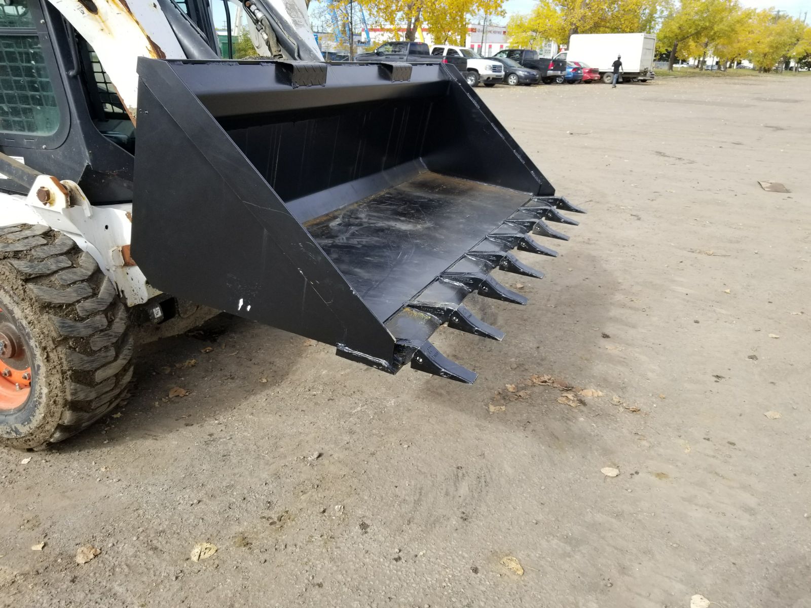 80" skid steer digging bucket with removable teeth

Heavy-duty bucket on job site with loader

Front view of 84-inch skid steer bucket

Skid steer digging into dirt with steel bucket

Wear strips and teeth close-up for material handling