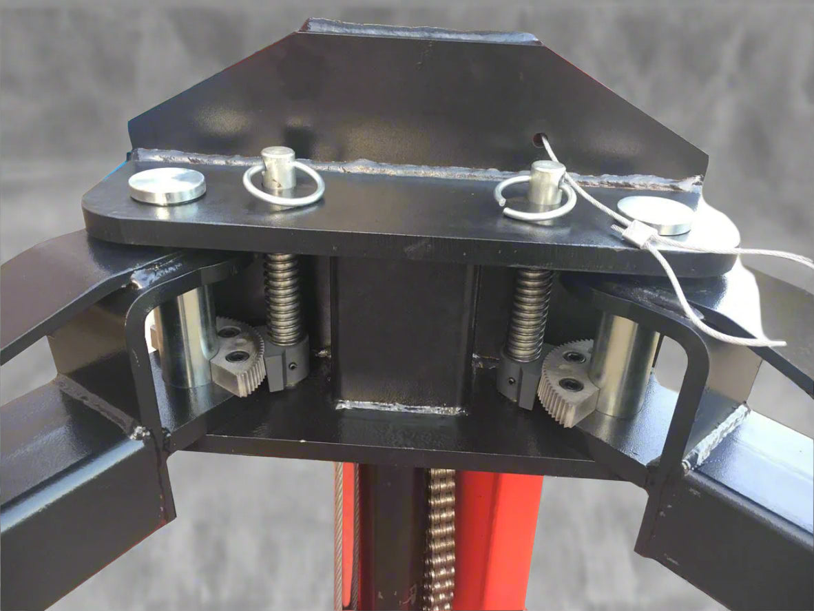 Red 2-post car hoist installed in garage

Close-up of safety lock and lift arms

Base of the lift showing manual release system

Top bar and symmetrical arm configuration