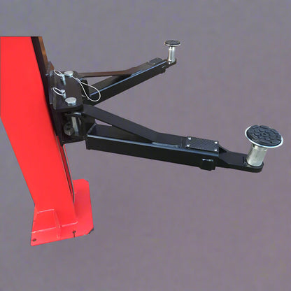 Red 2-post car hoist installed in garage

Close-up of safety lock and lift arms

Base of the lift showing manual release system

Top bar and symmetrical arm configuration