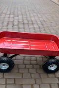 Red heavy-duty utility wagon shown on gravel with black handle