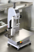 Full front view of a commercial frozen meat and bone saw machine
Side angle of a stainless steel cutting saw in a commercial kitchen
Bone saw machine in use, cutting frozen meat
Operator slicing frozen beef bones with an electric meat saw
Commercial food processing bone cutting equipment in operation
Close-up of adjustable blade on automatic bone saw