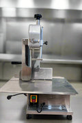Full front view of a commercial frozen meat and bone saw machine
Side angle of a stainless steel cutting saw in a commercial kitchen
Bone saw machine in use, cutting frozen meat
Operator slicing frozen beef bones with an electric meat saw
Commercial food processing bone cutting equipment in operation
Close-up of adjustable blade on automatic bone saw