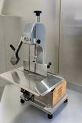 Full front view of a commercial frozen meat and bone saw machine
Side angle of a stainless steel cutting saw in a commercial kitchen
Bone saw machine in use, cutting frozen meat
Operator slicing frozen beef bones with an electric meat saw
Commercial food processing bone cutting equipment in operation
Close-up of adjustable blade on automatic bone saw